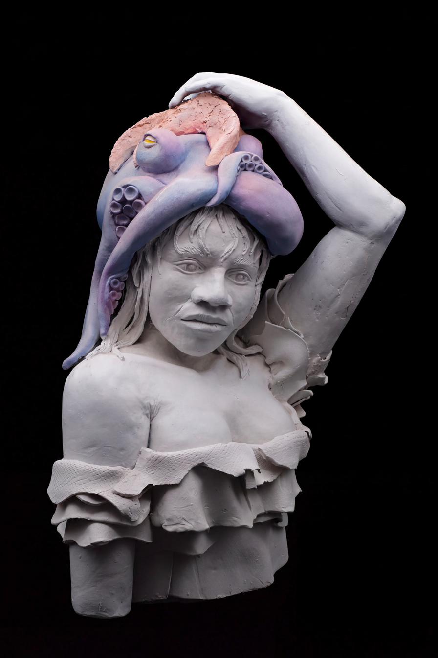 Clay bust of a young girl with a large purple octopus draped over her head like a hood, one of its tentacles trailing down her shoulder while she holds it in place with her raised hand